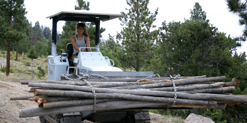 Student driving a machine carrying logs