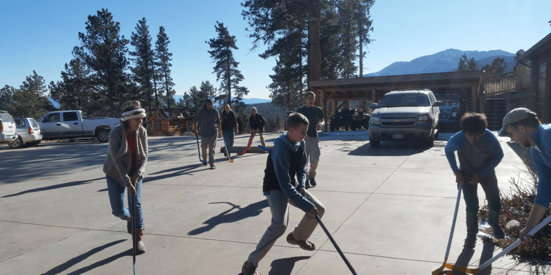 People playing hockey in the driveway
